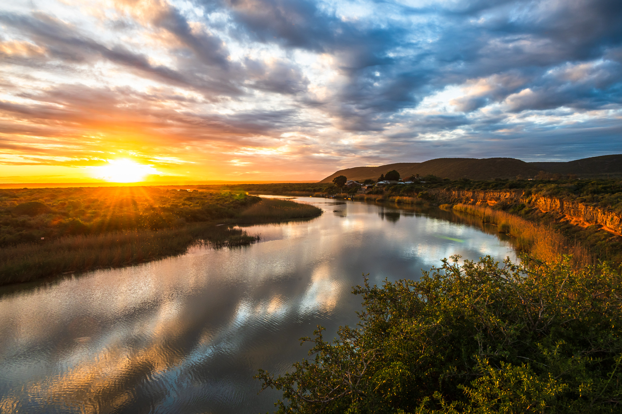 Sunset reflects across the calm waters of the Sundays River near Addo, where wetlands, reed beds and river channels wind toward the coast.