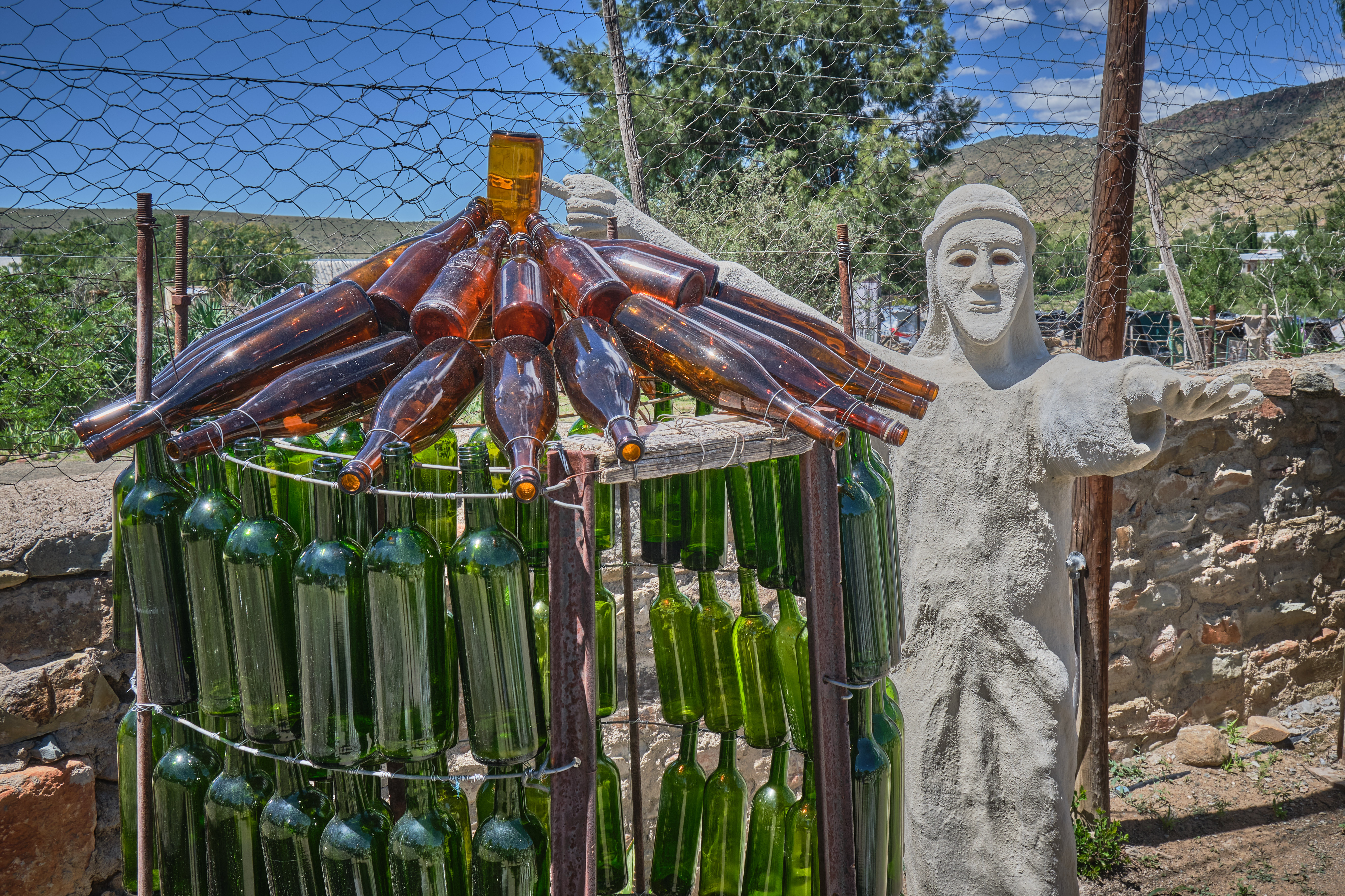 Glass bottle sculpture and concrete figure in the Owl House sculpture garden in Nieu-Bethesda, Eastern Cape, South Africa.