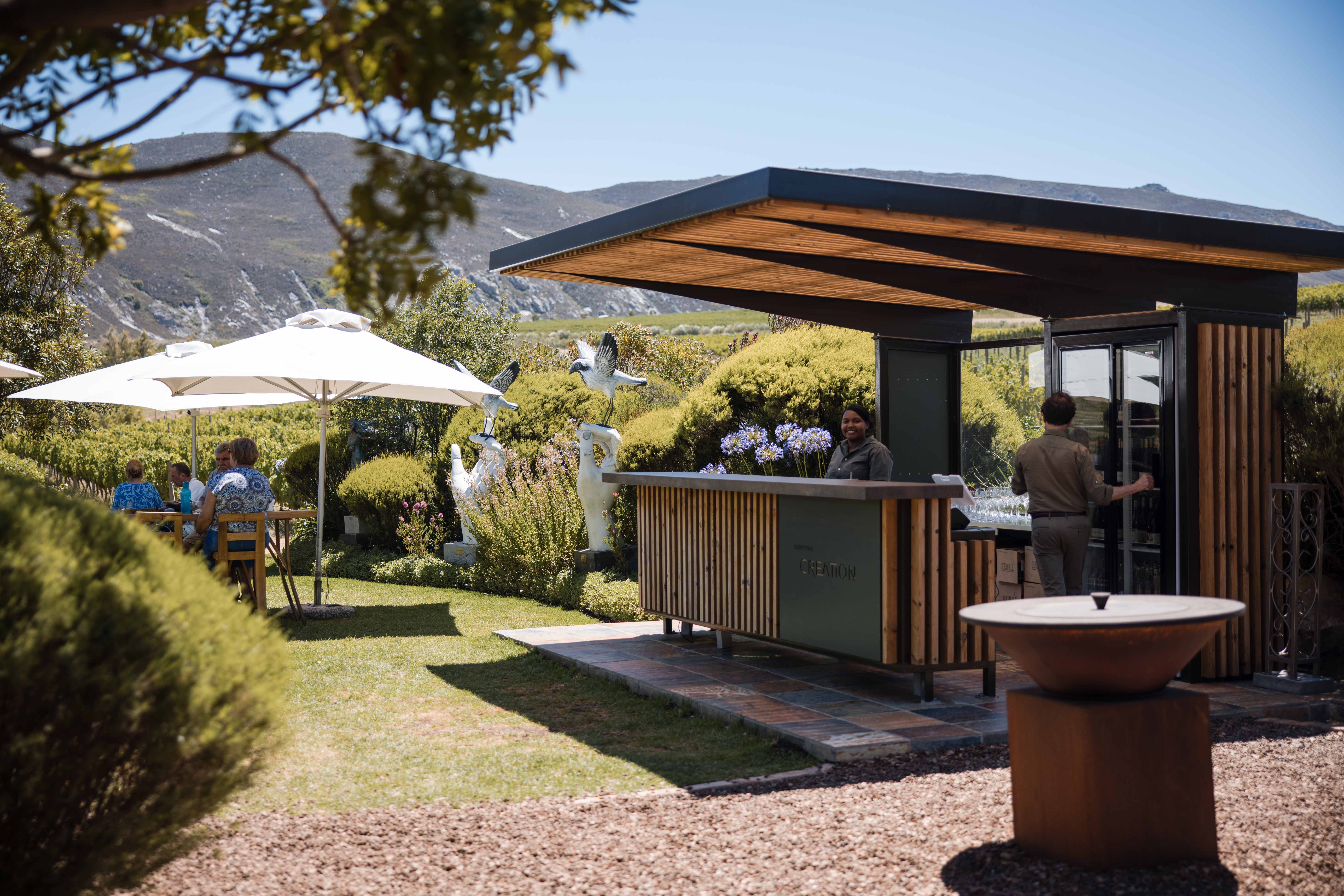 Guests enjoying the outdoor tasting area at Creation Wines in the Hemel-en-Aarde Valley, Overberg, South Africa.