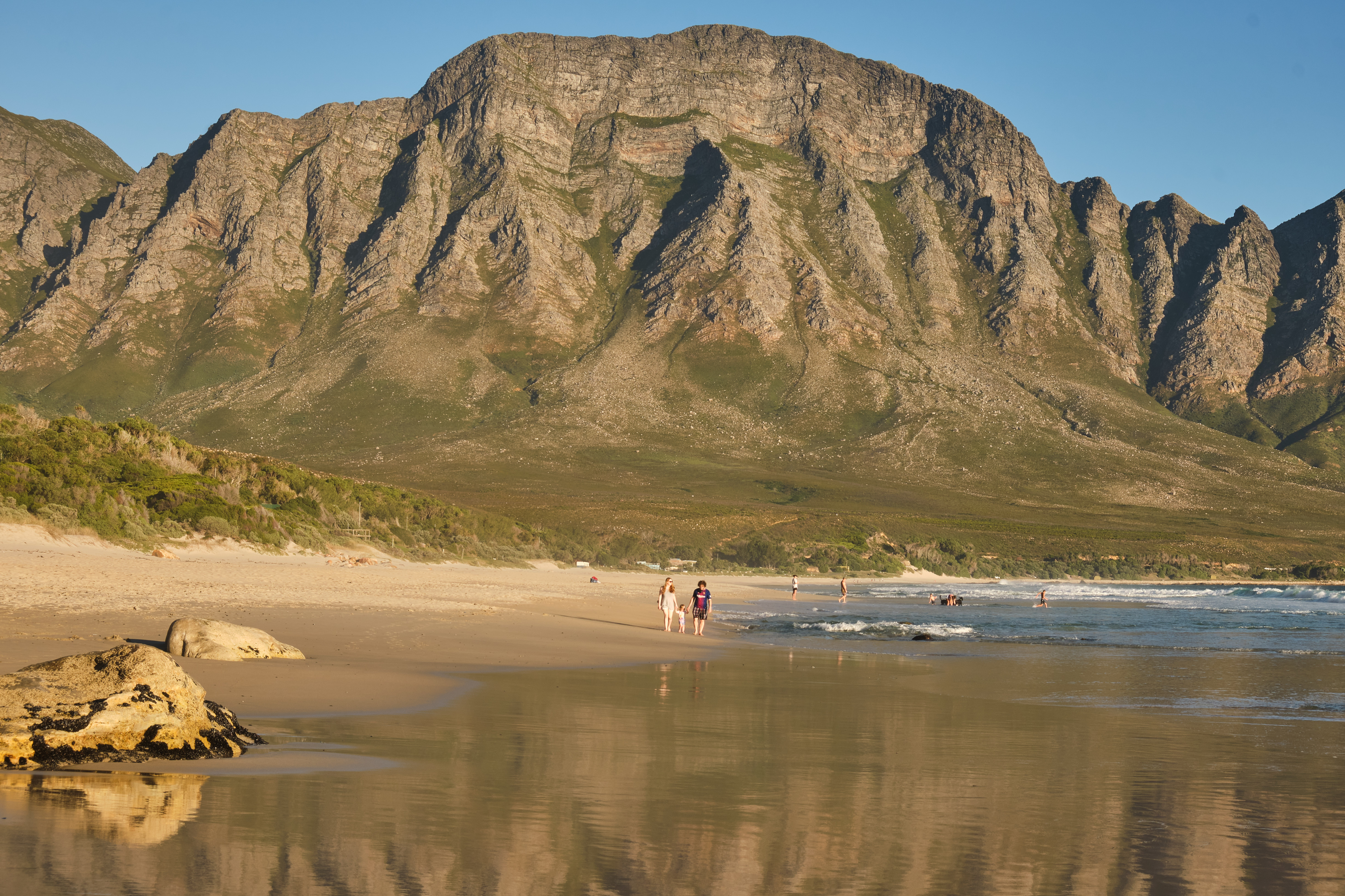 Wet sand reflections and coastal mountain scenery at Kogel Bay along the Kogelberg coastline in the Western Cape, South Africa.