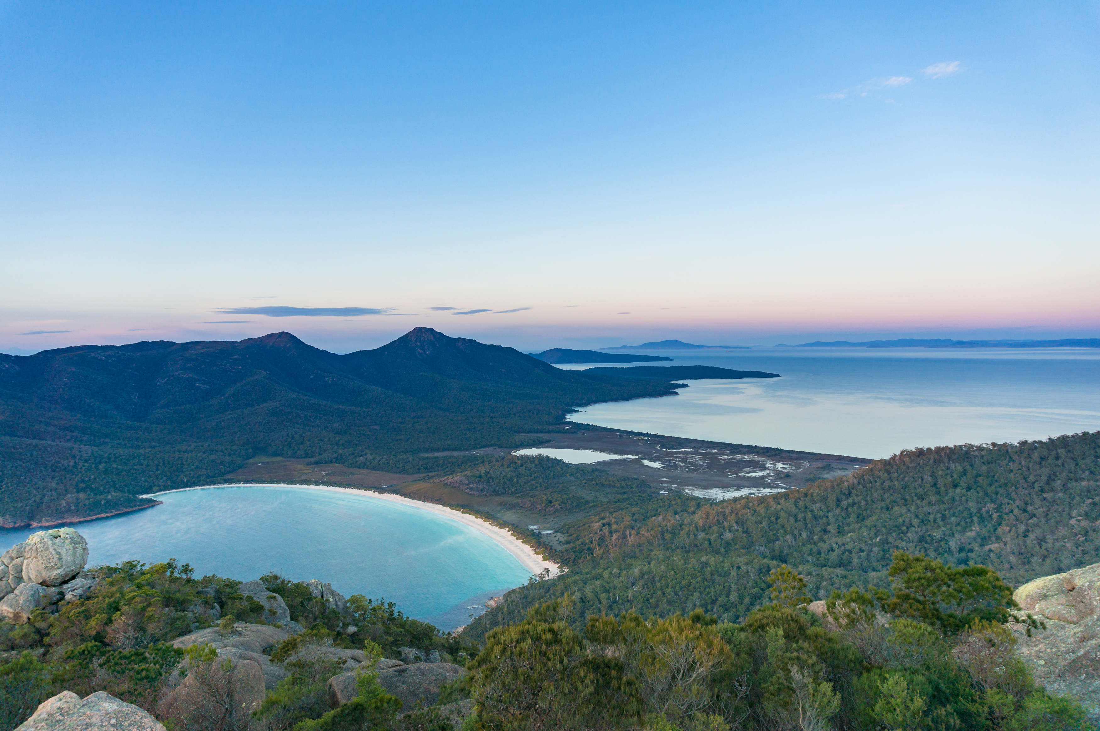 Aerial view on picturesque bay with beach and mountains covered with forest. Wineglass bay in Freicynet national park, Tasmania, Australia