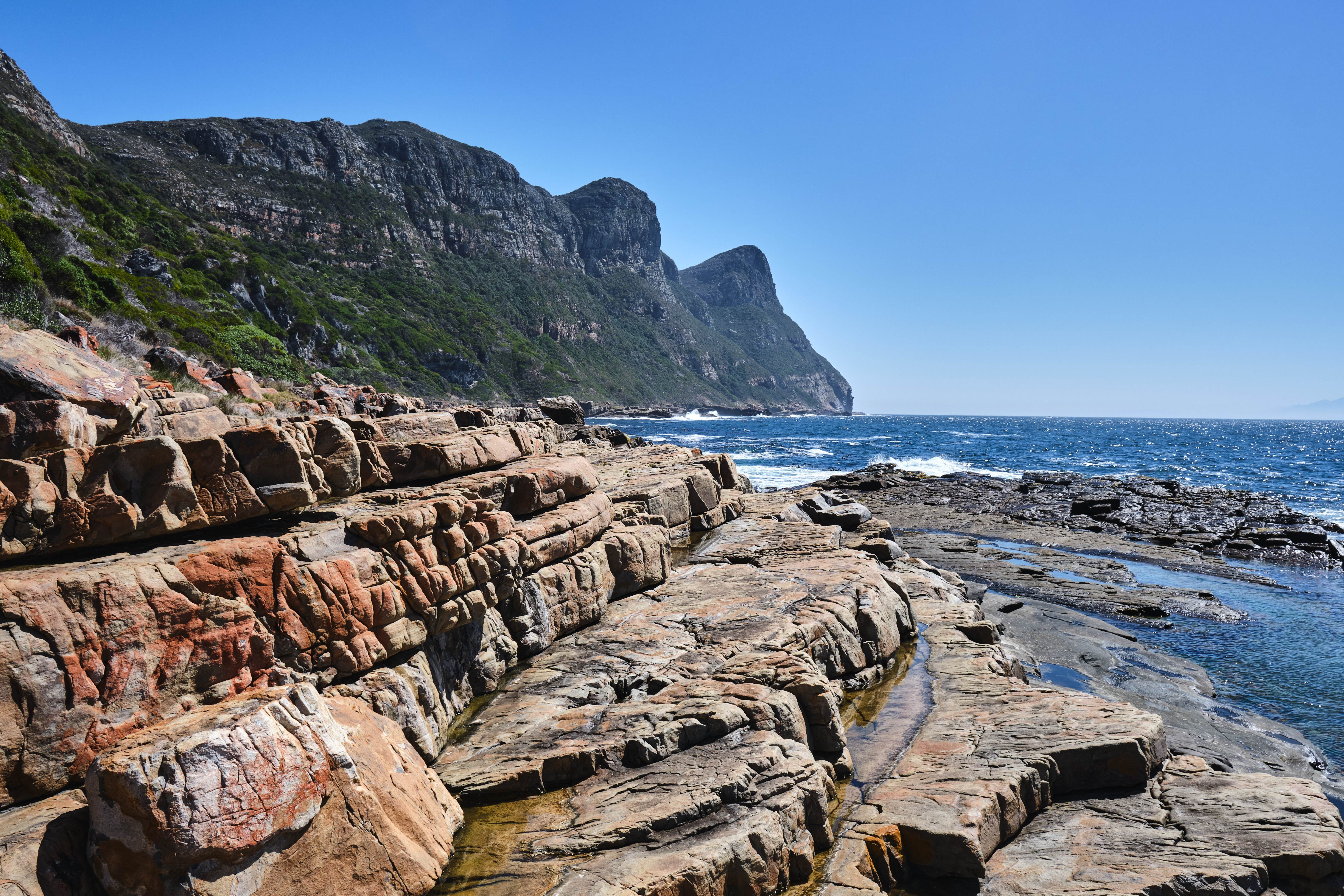 Rock shelves and tidal pools at Venus Pools along the Cape of Good Hope coastline in Table Mountain National Park, South Africa.