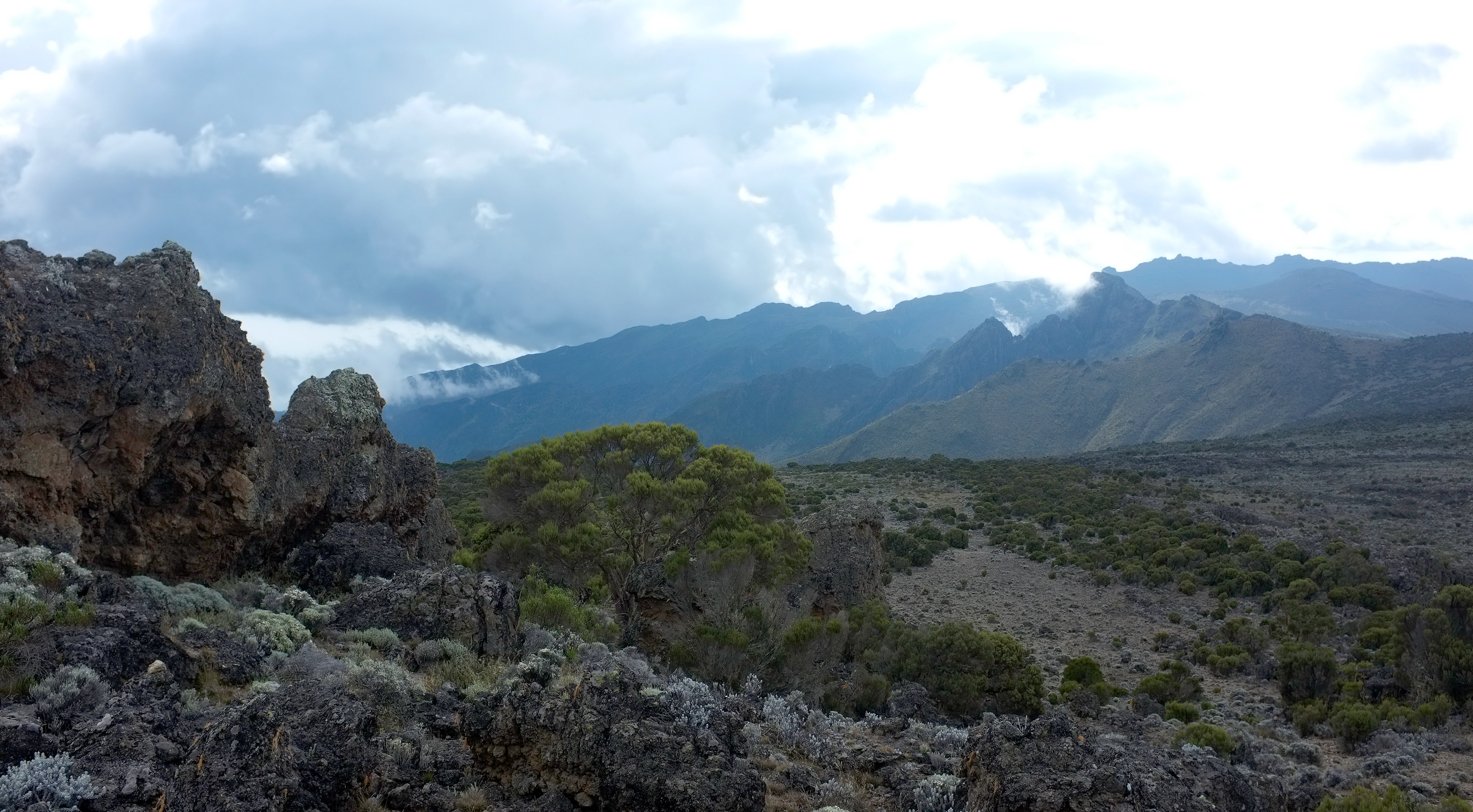 Rocky volcanic terrain and mountain slopes on the Shira Plateau of Mount Kilimanjaro, Tanzania, at approximately 4,000 metres above sea level.