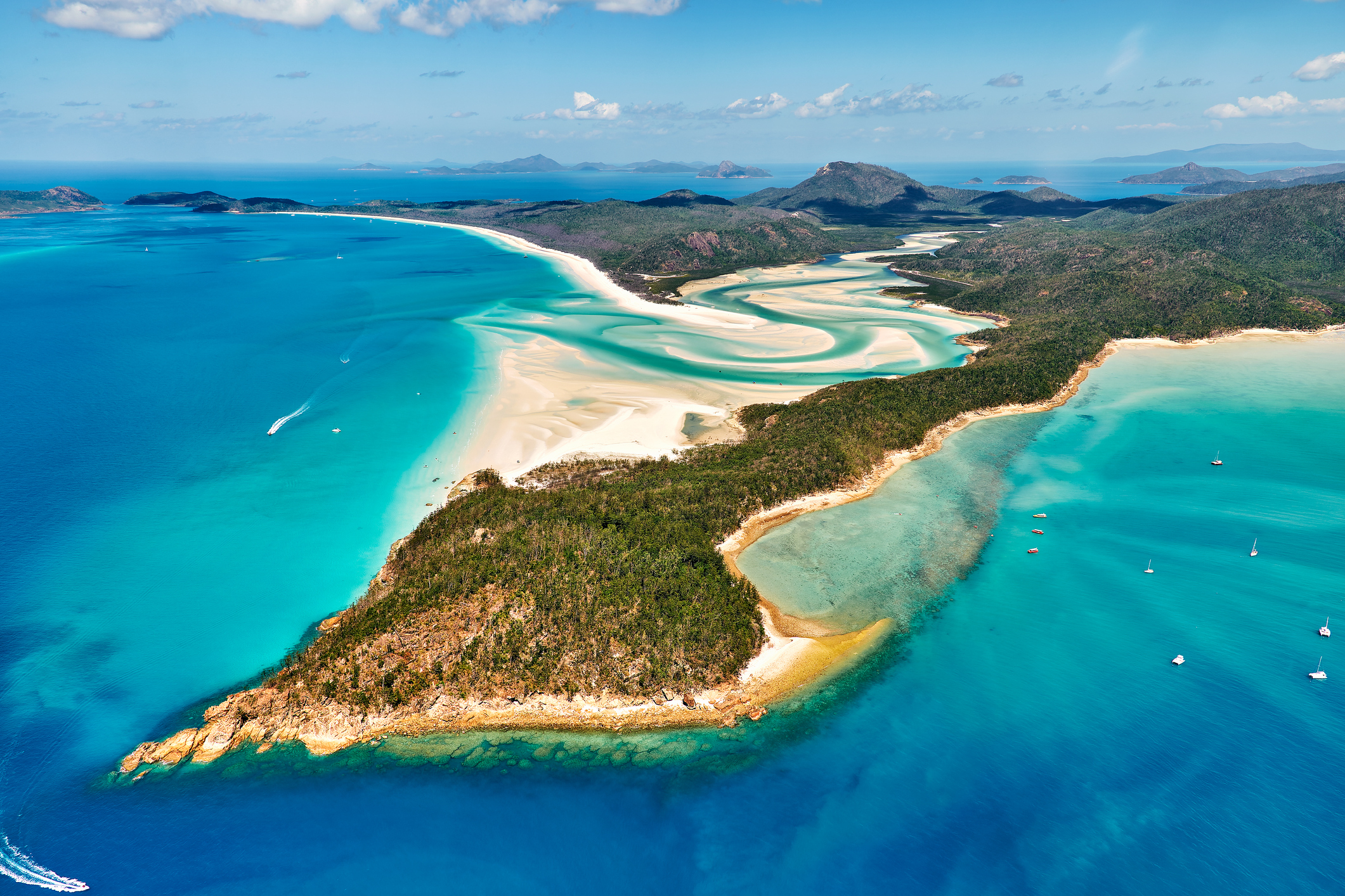 Aerial view of Whitehaven Beach and Hill Inlet with white silica sand, turquoise water and forested Whitsunday Islands, Queensland, Australia.