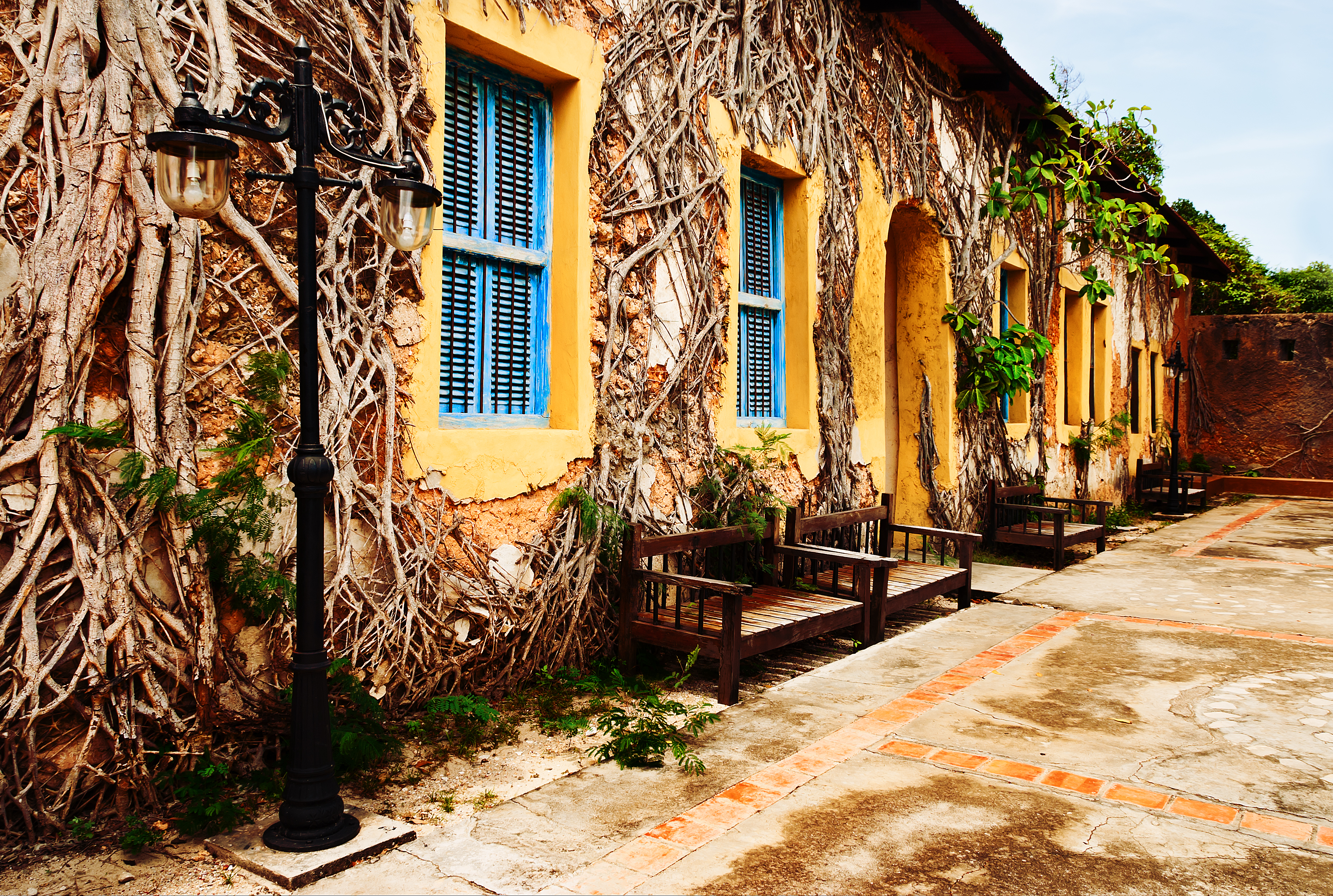 Courtyard of the historic prison complex on Prison Island, Zanzibar, with vine-covered walls and restored colonial architecture.