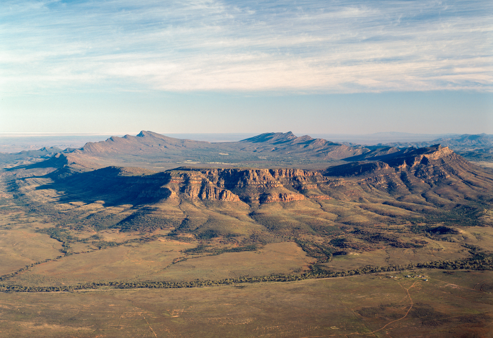 Aerial view of Wilpena Pound's sweeping mountain ridges and sandstone escarpments in the Flinders Ranges, South Australia.