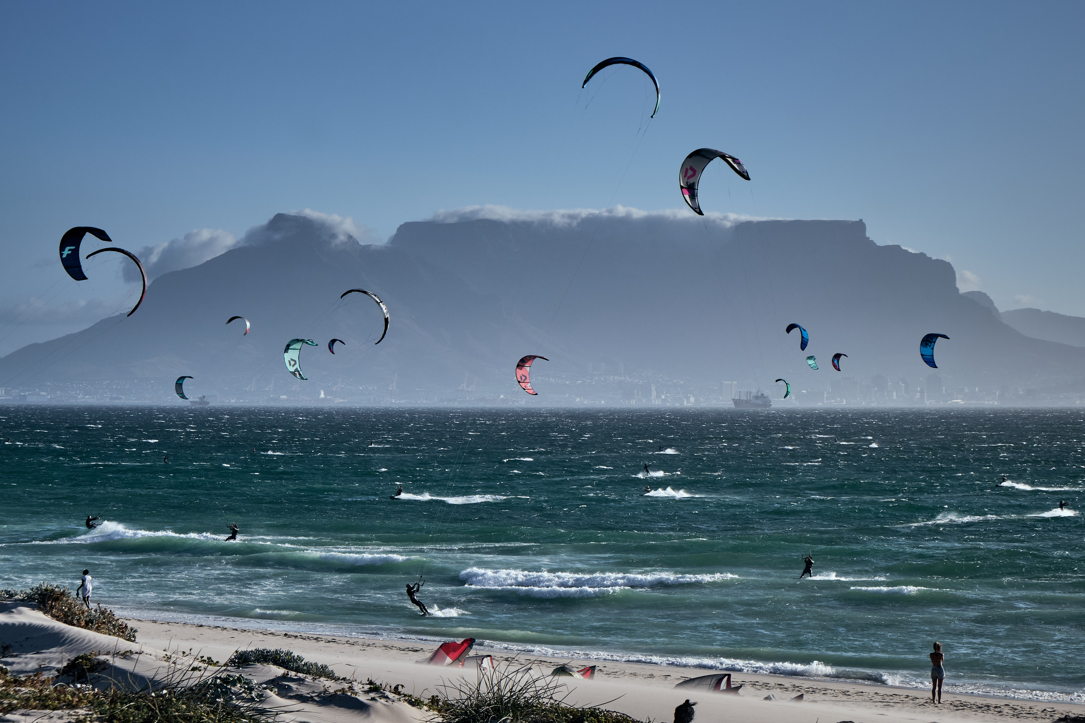 Kite surfers at Bloubergstrand beach with Table Mountain in the background across Table Bay in Cape Town.