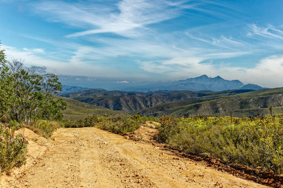 Gravel mountain road overlooking the Baviaanskloof mountain ranges from the Elandsberg Mountains near Patensie, South Africa.
