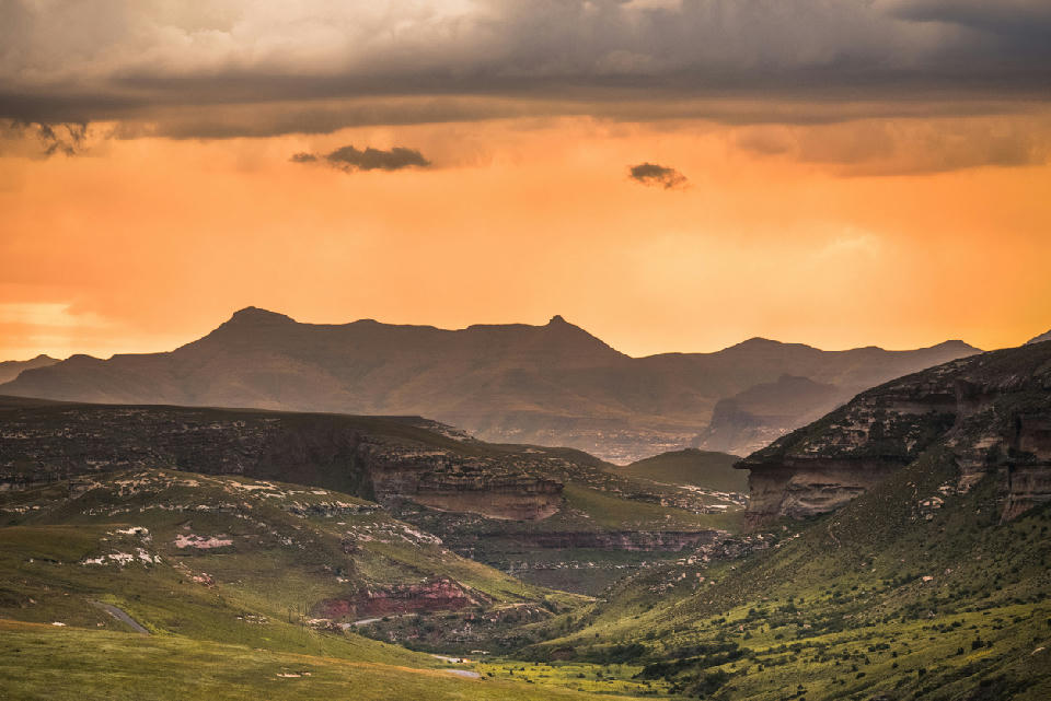 Sunset storm clouds over the mountain valleys and sandstone highlands of the Golden Gate and Maluti Foothills region in South Africa.