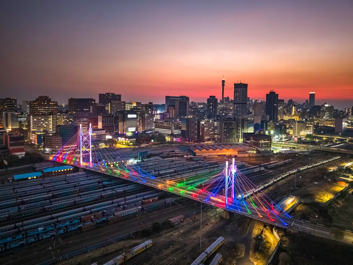 Aerial view of the Johannesburg skyline and Nelson Mandela Bridge at sunset in Gauteng, South Africa.