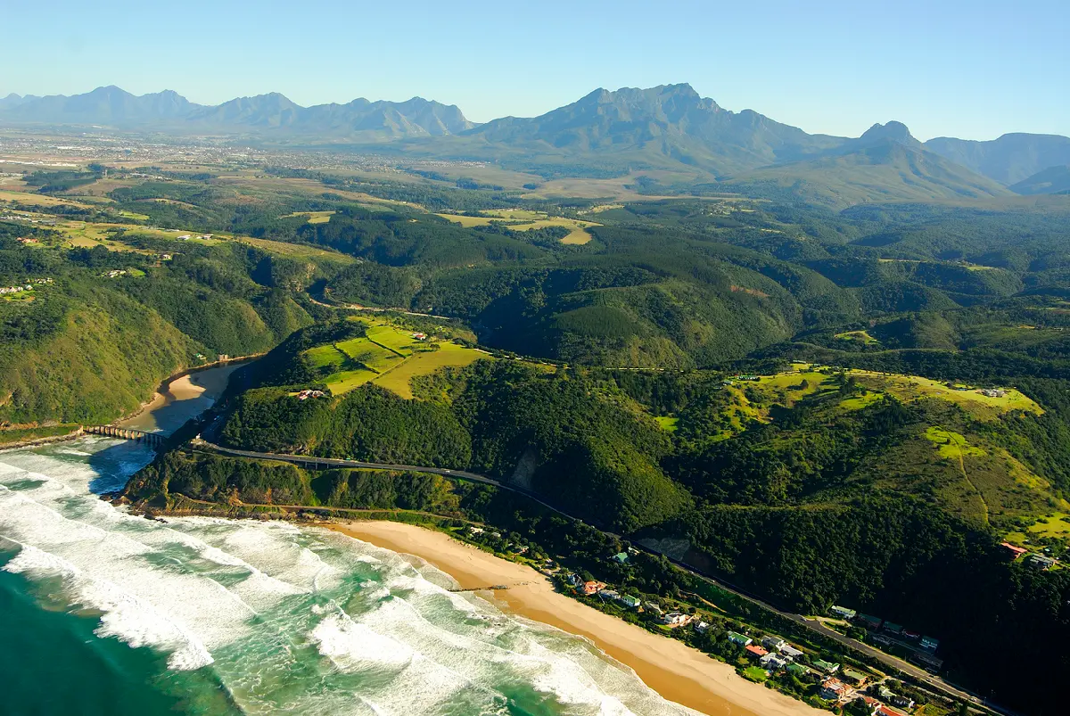 Aerial panorama of Wilderness showing sandy beaches, estuary, forested hills and the Outeniqua Mountains on South Africa's Garden Route.