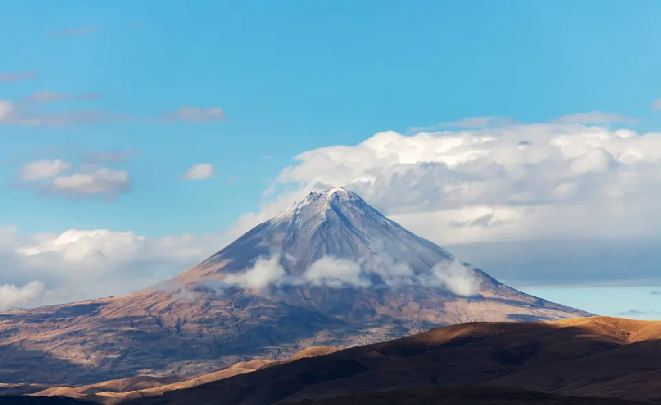 Snow-covered summit of Mount Ararat rising above the highlands of Eastern Turkey beneath clouds.