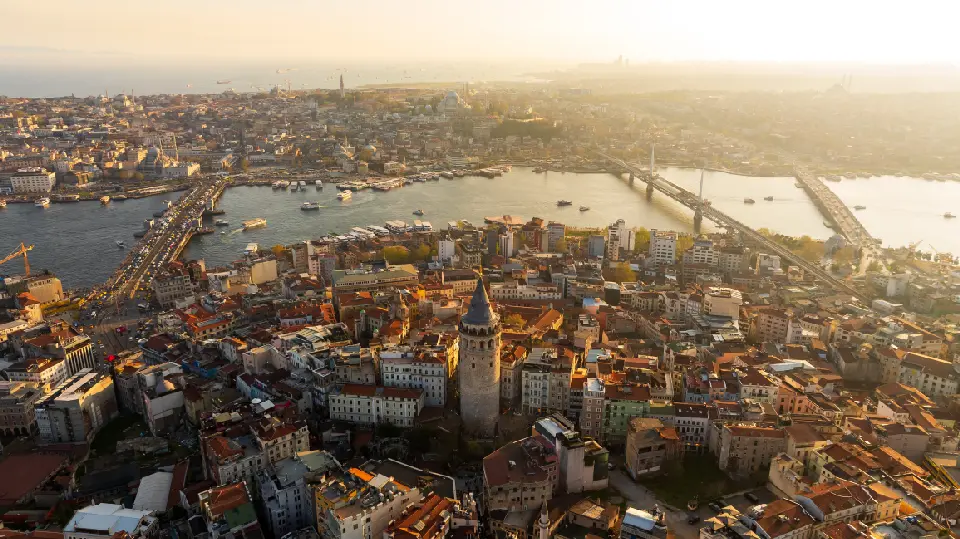 Aerial view of Galata Tower, Galata Bridge and the Golden Horn at golden hour in Istanbul.