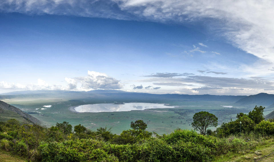 Panoramic landscape of Ngorongoro Crater and Lake Magadi surrounded by the volcanic highlands of Tanzania's Ngorongoro Conservation Area.