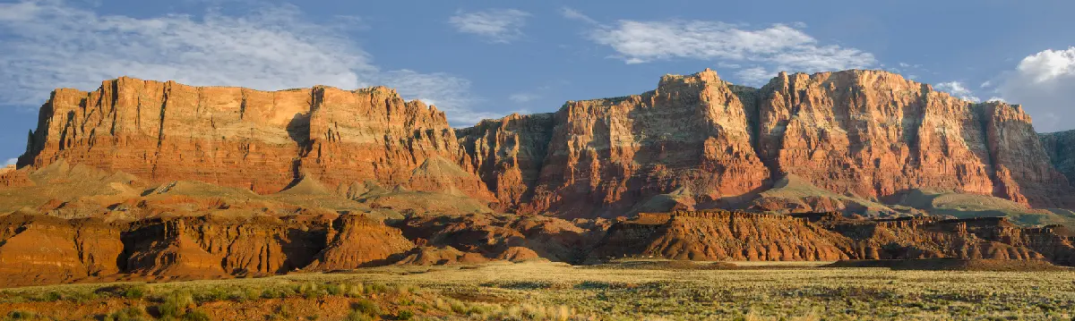 Layered red sandstone cliffs of Vermilion Cliffs above desert landscape in northern Arizona