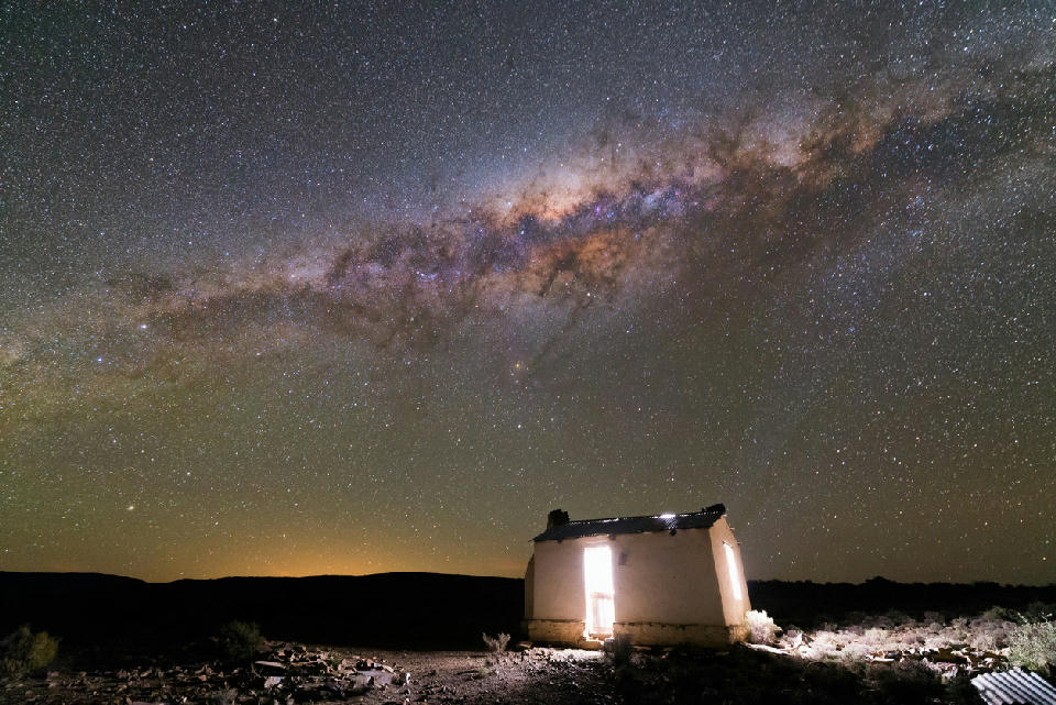 The Milky Way arching across a star-filled night sky above a remote Karoo cottage near Sutherland, South Africa.