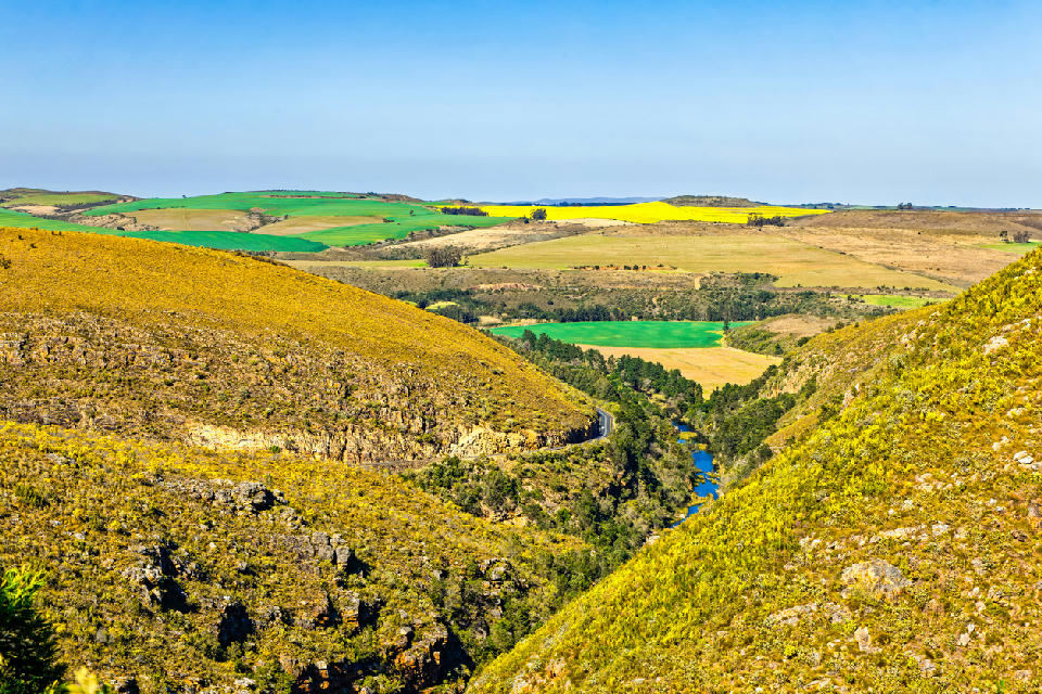 Tradouw Pass cutting through rugged hills toward patchwork farmland and coastal plains near Barrydale and Swellendam in the Western Cape, South Africa.