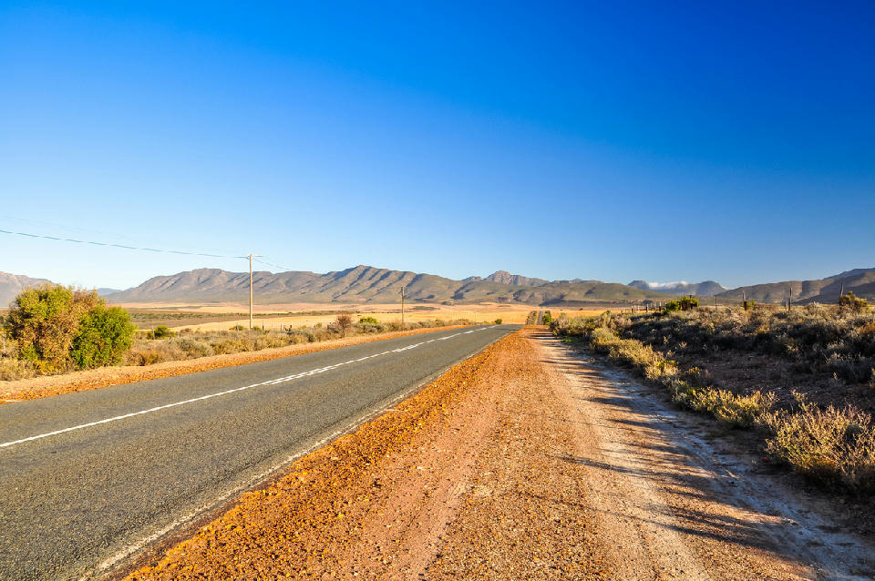 Route 62 near Oudtshoorn in the Klein Karoo with the Swartberg Mountains rising beyond the road in the Western Cape.