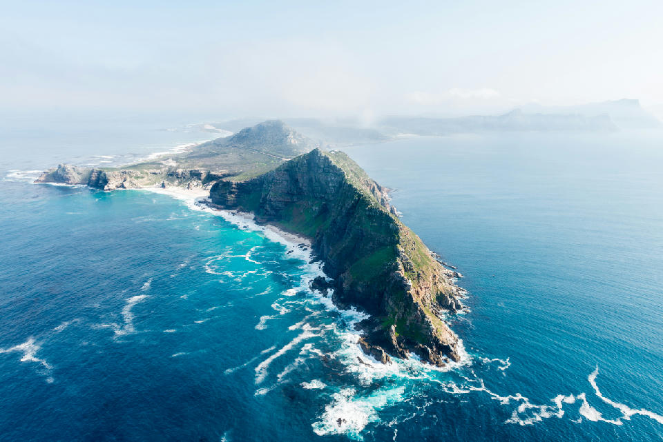 Aerial view of Cape Point showing steep cliffs and a narrow peninsula surrounded by the Atlantic Ocean.