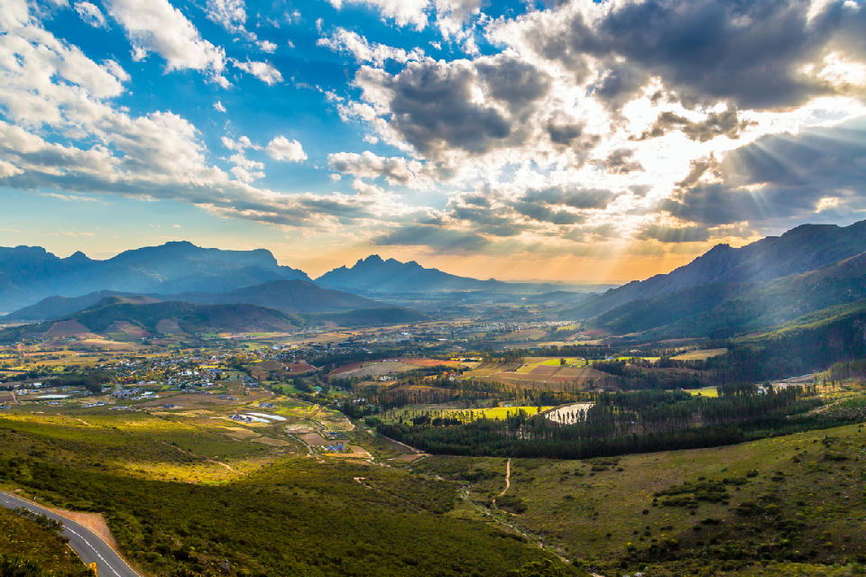 Scenic aerial view of Franschhoek village with vineyards, valleys and mountain ranges in the Cape Winelands of South Africa.