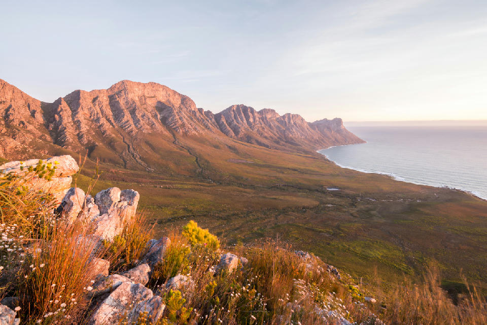 View from the Kogelberg mountains across fynbos-covered slopes and the False Bay coastline in the Overberg region of the Western Cape, South Africa.