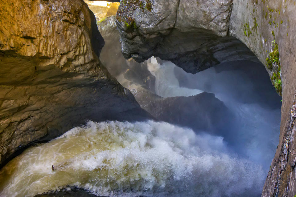Powerful glacier-fed water rushing through a narrow cavern at Trümmelbach Falls, carving smooth rock walls inside the mountain in Lauterbrunnen Valley, Switzerland.