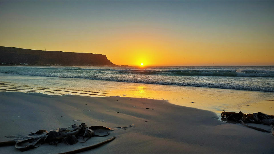 Atlantic Ocean sunset with sandy beach and coastal headland at Baboon Point near Elands Bay on South Africa's West Coast.