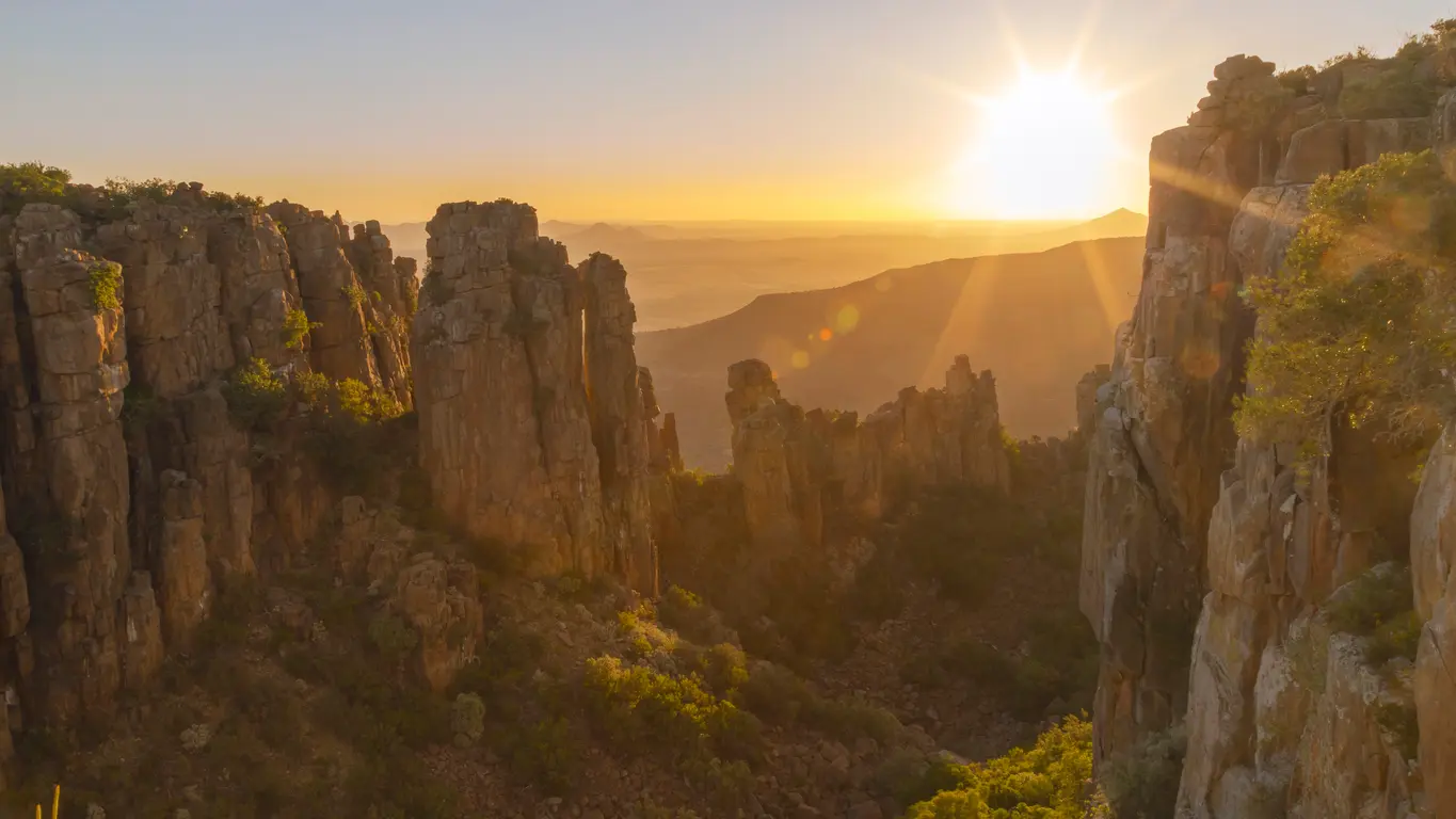 Sunrise illuminating the dramatic sandstone cliffs and rock pinnacles of the Valley of Desolation in Camdeboo National Park near Graaff-Reinet, Eastern Cape, South Africa.