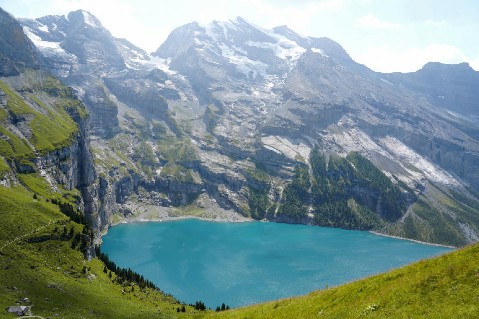 Oeschinensee below steep alpine cliffs and glacier-fed peaks in the Bernese Alps, Switzerland.