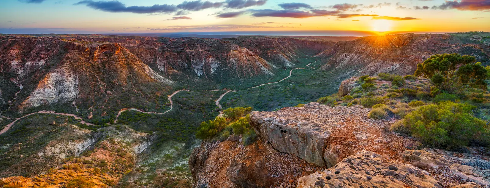 Sunrise illuminates the rugged walls and winding valley of Charles Knife Canyon.