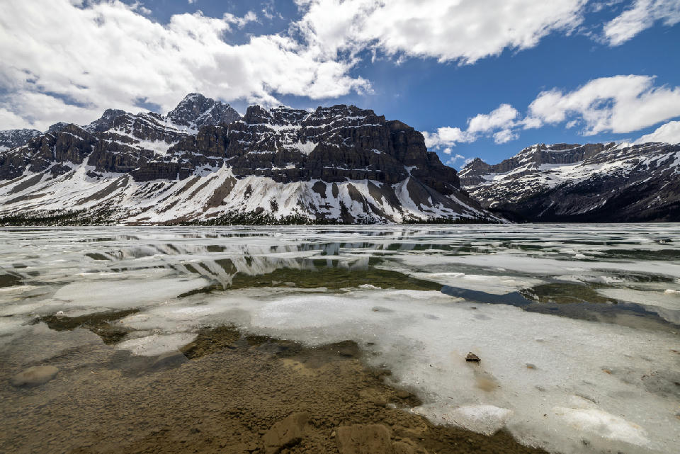 Bow Lake partially frozen with ice patterns and mountain backdrop, Banff National Park, Alberta, Canada
