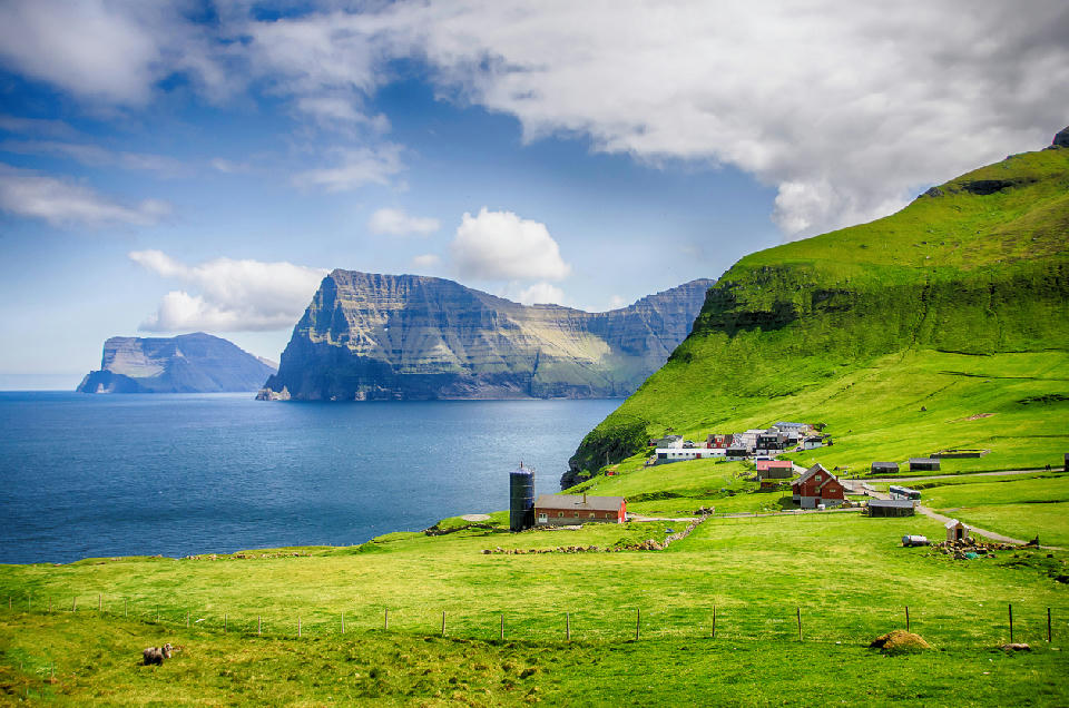 Green cliffs and coastal farmland on Kalsoy in the Faroe Islands near the trail to Kallur Lighthouse.