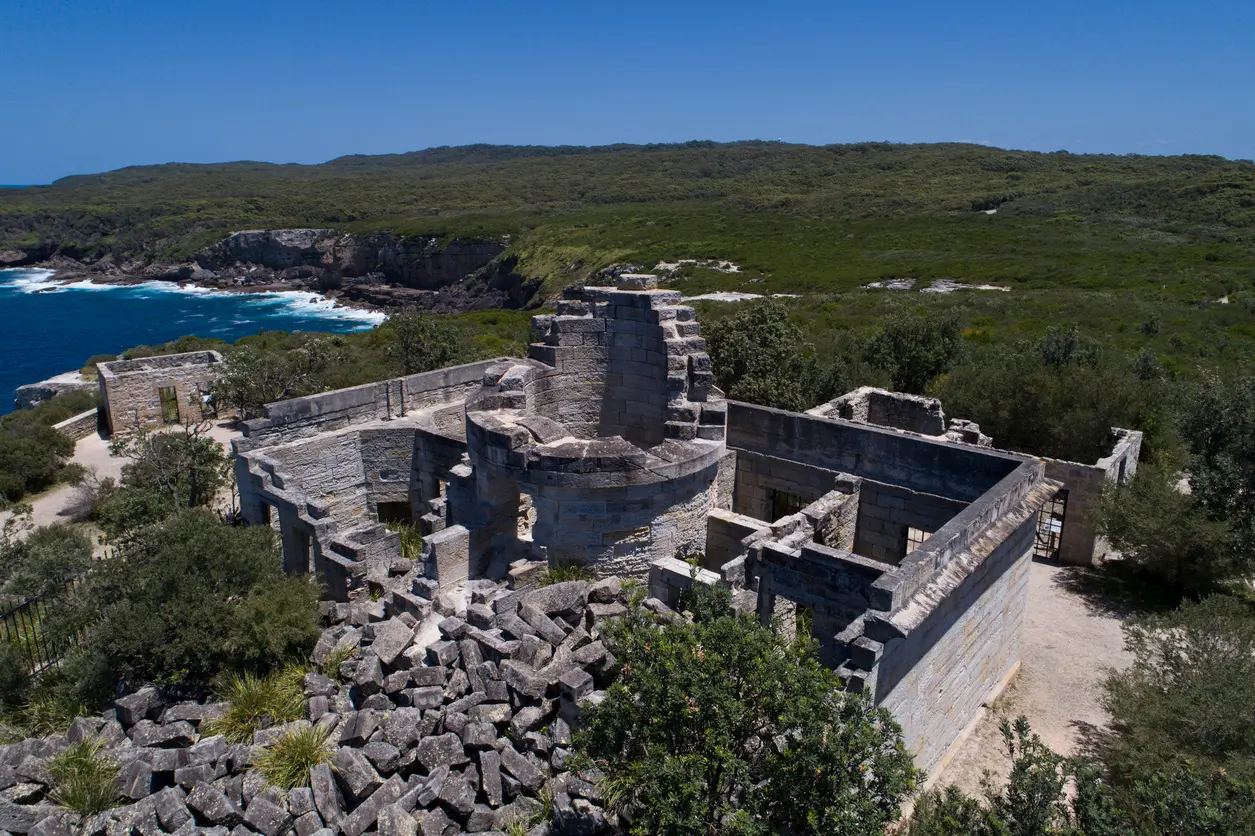 Stone ruins of Cape St George Lighthouse overlooking the rugged coastal cliffs and blue ocean of Jervis Bay Territory.