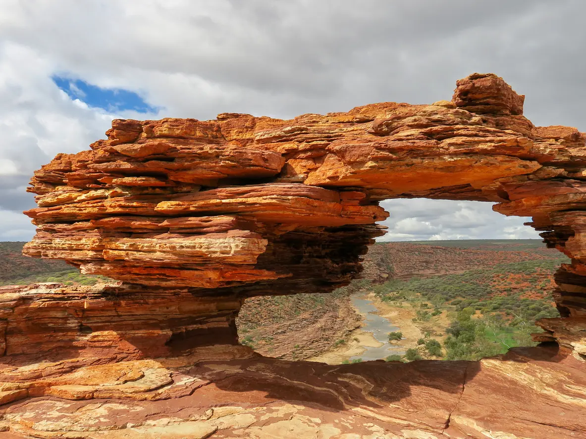 Close view through the layered red sandstone opening of Nature’s Window towards the Murchison River gorge.