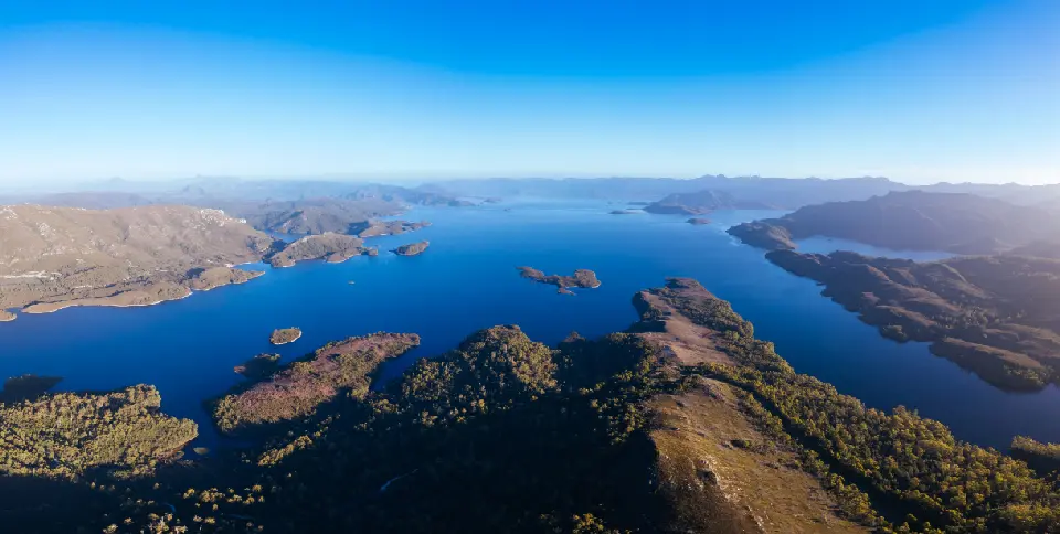 Aerial view of Lake Pedder surrounded by islands and rugged mountain ranges in Southwest National Park, Tasmania, Australia.