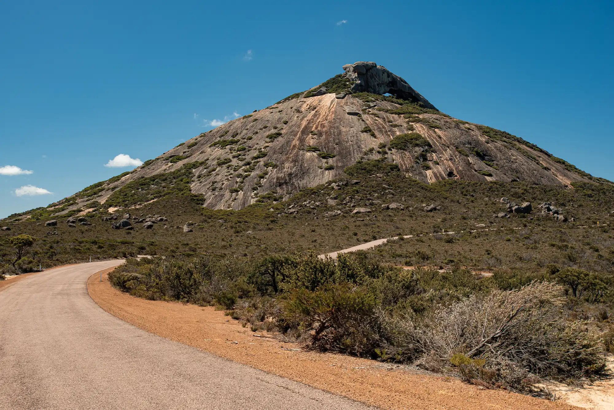 Road approaching Frenchman Peak and its granite summit in Cape Le Grand National Park, Western Australia.