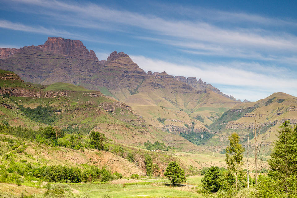View of Champagne Castle and the surrounding Drakensberg peaks above green foothills and valleys in the Central Drakensberg, KwaZulu-Natal, South Africa.