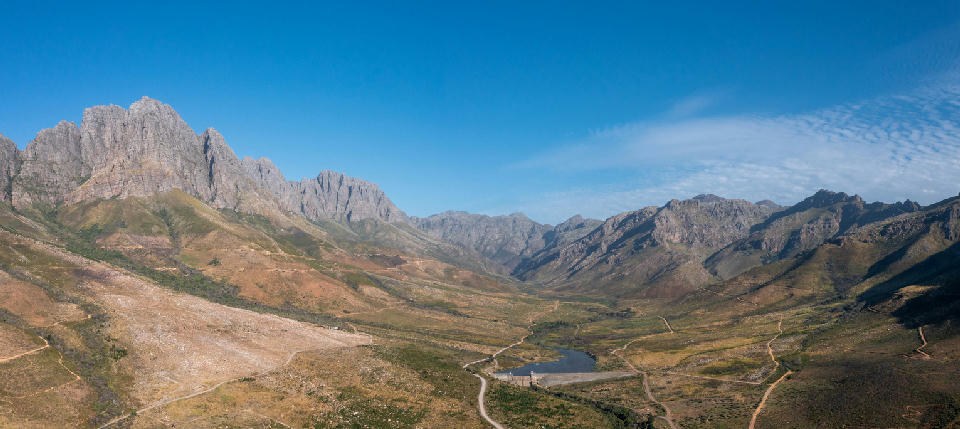 Aerial view of Jonkershoek Nature Reserve with mountain peaks, valley roads and reservoir near Stellenbosch.