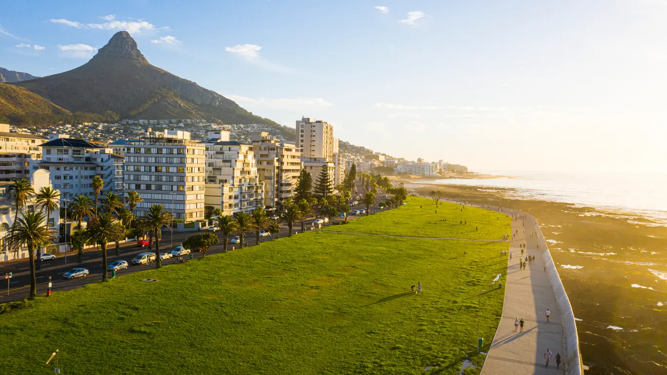 Aerial view of the Sea Point Promenade with Lion’s Head rising behind the Sea Point coastline in Cape Town, South Africa.
