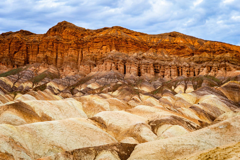 Red Cathedral cliffs above Golden Canyon with layered badlands foreground below Zabriskie Point Death Valley California