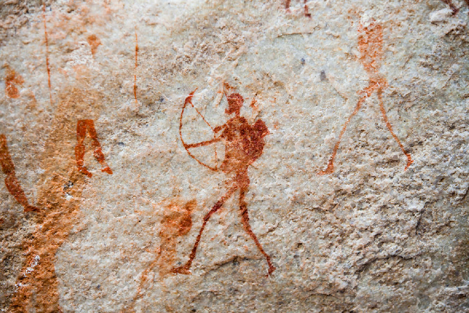 Ancient San rock art depicting a hunter with a bow and arrow on a sandstone wall along the Sevilla Rock Art Trail in the Cederberg Mountains, Western Cape, South Africa.