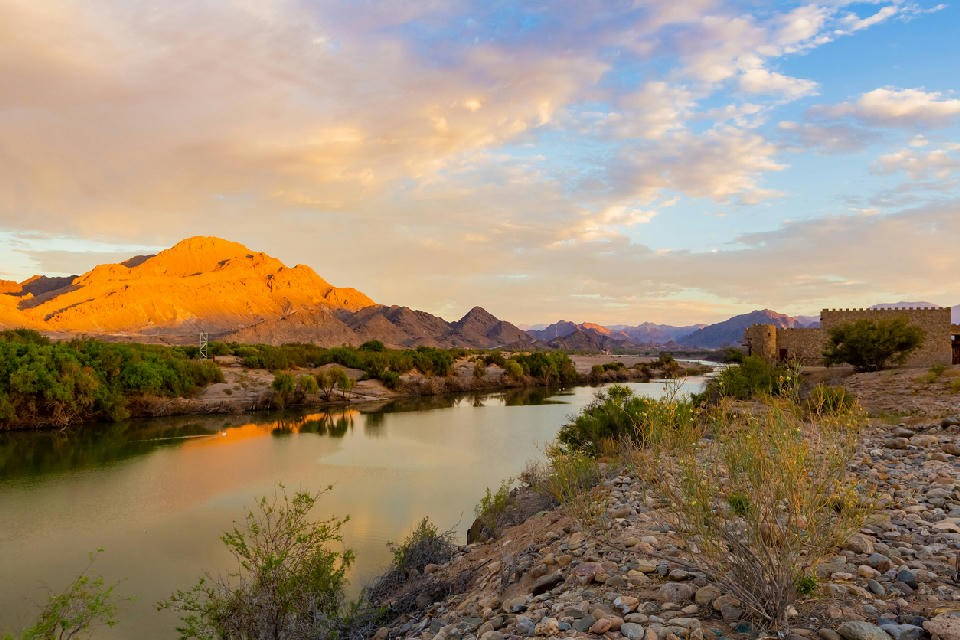 The Orange River flowing through the mountainous Richtersveld landscape at sunset.