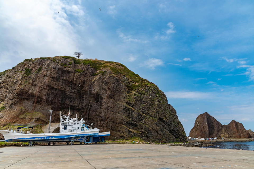 Olonko Rock and lighthouse at Utoro Port in Shiretoko, Hokkaido, showing the steep coastal rock formation