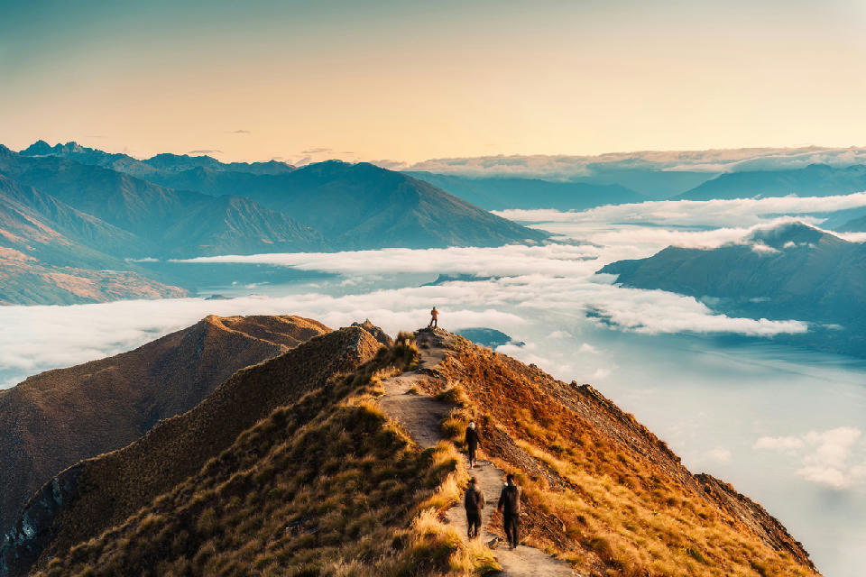 The Roys Peak ridgeline overlooks Lake Wanaka and Glendhu Bay, with low cloud filling the surrounding valleys and mountain basins.