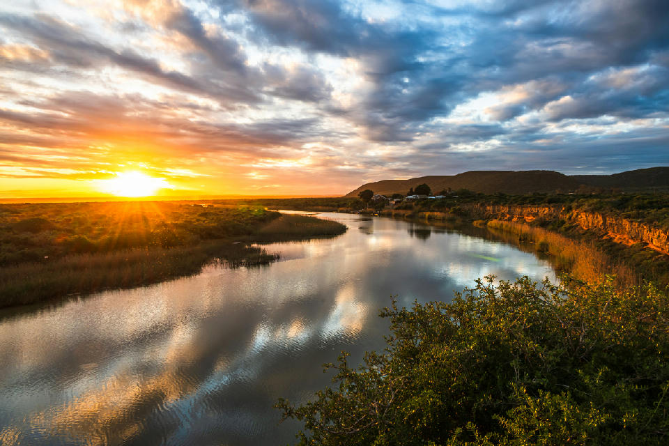 Sunset reflects across the calm waters of the Sundays River near Addo, where wetlands, reed beds and river channels wind toward the coast.