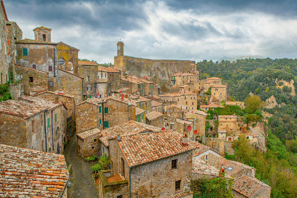 Medieval town of Sorano built on volcanic tuff cliffs, with stone buildings, narrow streets, and a bell tower in southern Tuscany, Italy.