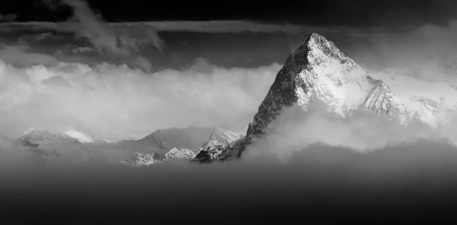 Eiger North Face rising above clouds in a monochrome panoramic view, Bernese Alps, Switzerland.