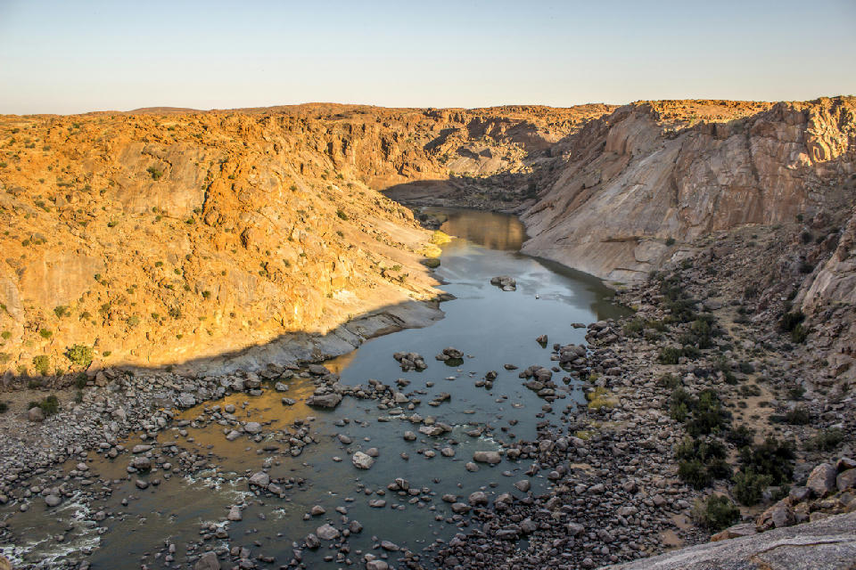The Orange River winds between steep granite canyon walls viewed from Ararat Viewpoint in Augrabies Falls National Park, South Africa.