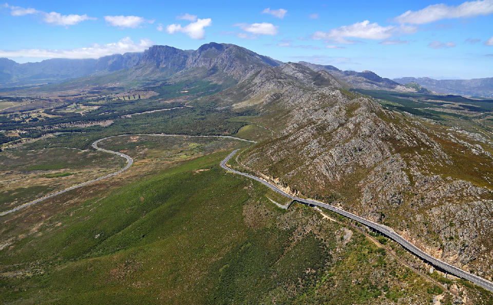 Aerial landscape of Sir Lowry’s Pass and mountain roads cutting through the Hottentots Holland Mountains near Elgin and False Bay in the Western Cape, South Africa.