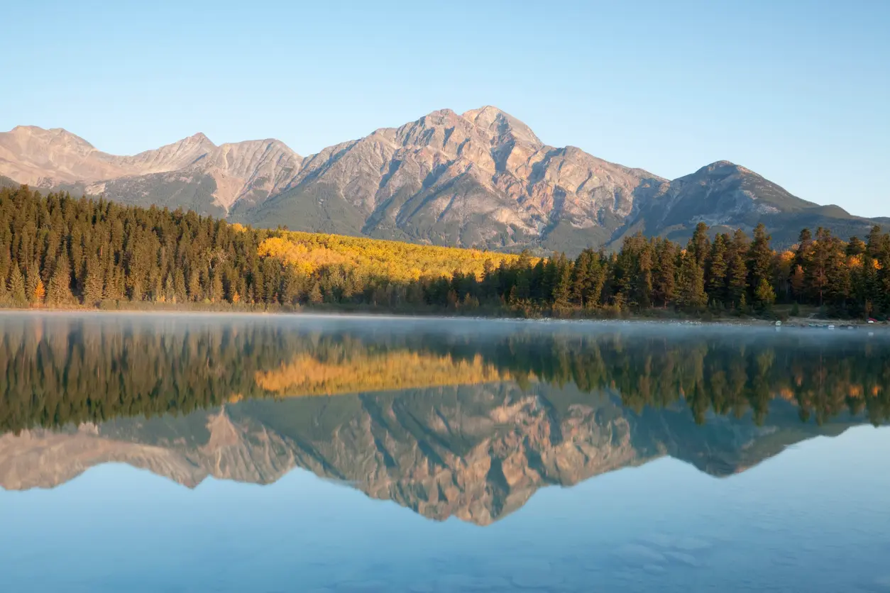 Patricia Lake at sunrise with mountain reflection, mist, and autumn forest